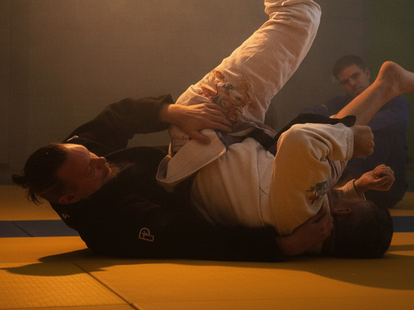Twee sporters in gi tijdens een BJJ-training
